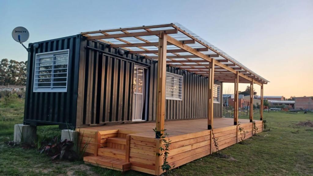 a house with a wooden deck in a field at BlackHouse in Federación