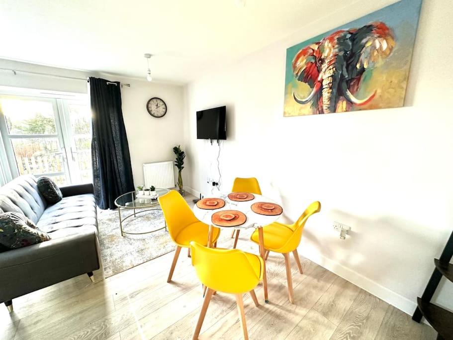 - un salon avec une table et des chaises jaunes dans l'établissement Luxury Dover suites near Ferry, à Kent