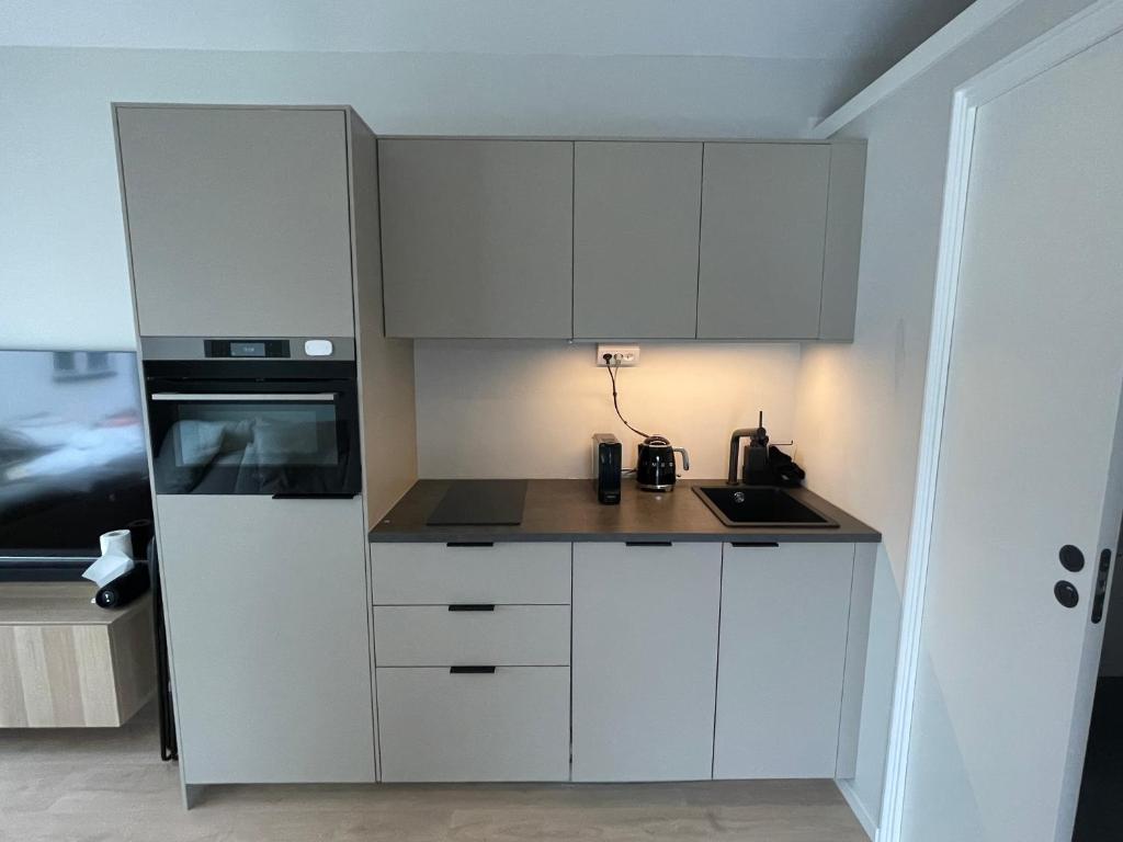 a small kitchen with white cabinets and a stove at Eget hus anno 2024 Danderyd, 15min till STHLM city in Danderyd