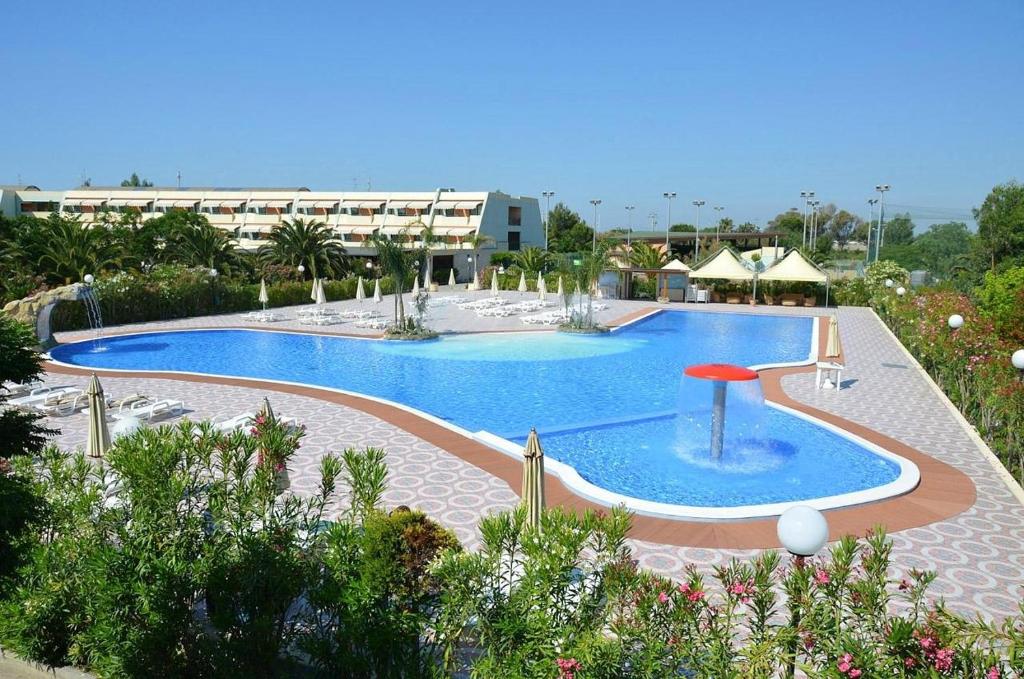 una grande piscina di fronte a un edificio di Resort Alessidamo Club Metaponto a Metaponto