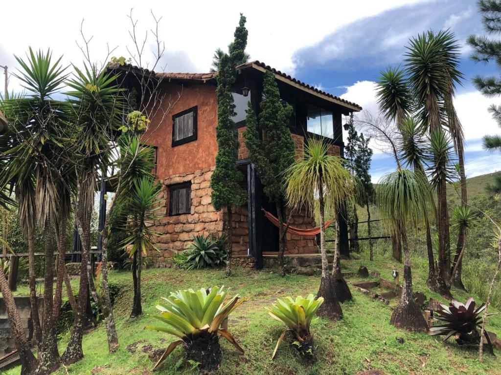 une maison avec des palmiers devant elle dans l'établissement Chalés Serra do Trovão, à Lavras Novas