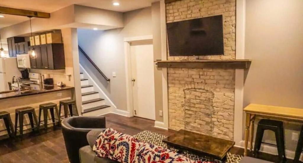 a living room with a fireplace with a tv on top at Housepitality - The Urban Roost 1 - Modern in Columbus