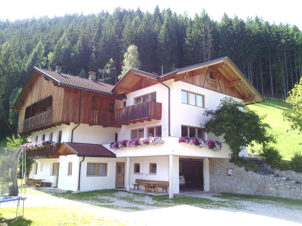 dom na wzgórzu z drzewami w tle w obiekcie Prestihof w mieście San Vigilio di Marebbe