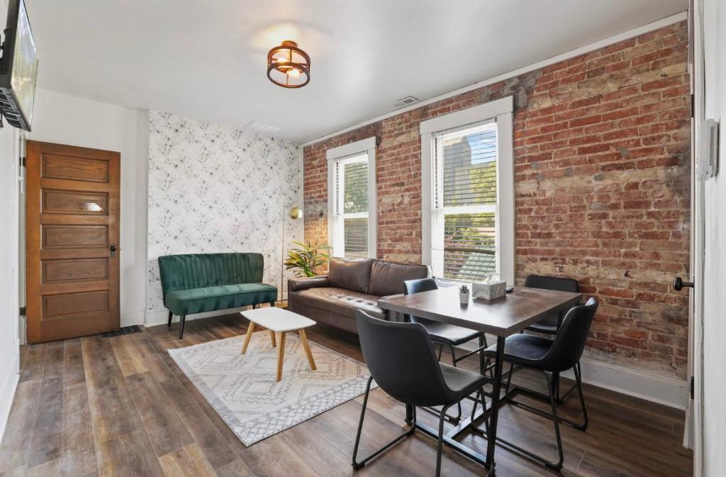 a living room with a brick wall and a couch at Housepitality - City View Loft - German Village in Columbus