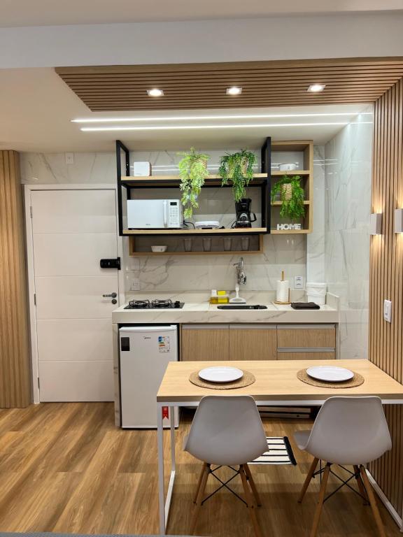 Hotel MARAVILHOSO APARTAMENTO NO LEBLON, a kitchen with a wooden table and two chairs at MARAVILHOSO APARTAMENTO NO LEBLON in Rio de Janeiro