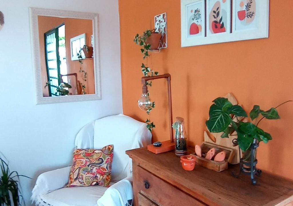 uma sala de estar com uma cadeira e um espelho em Casa de Praia Penha, Beto Carrero, 500m da Praia da Armação em Penha