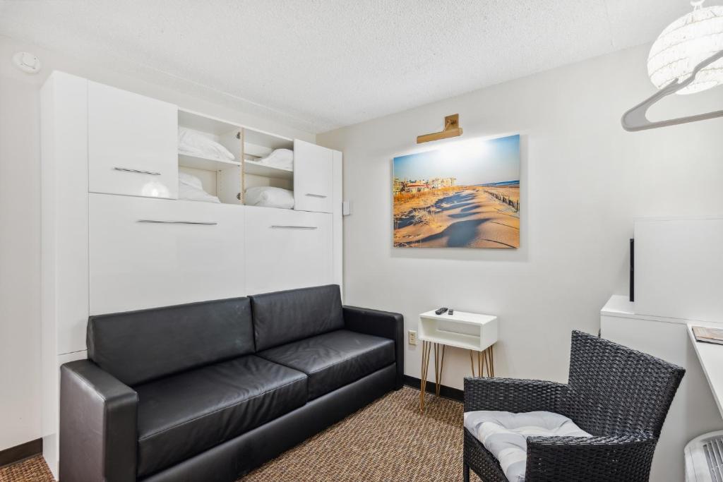 een woonkamer met een zwarte bank en een stoel bij Cape Suites Room 6 - Free Parking! Hotel Room in Rehoboth Beach