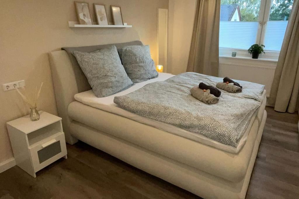 Una cama con dos ositos de peluche en un dormitorio en Stadtnah & Chic - Ihringshausen Retreat en Fuldatal