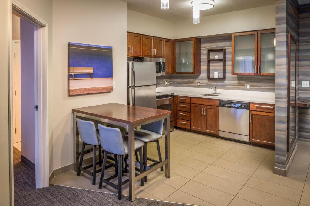 Il comprend une cuisine équipée d'une table en bois et d'un réfrigérateur. dans l'établissement Residence Inn by Marriott Williamsport, à Williamsport