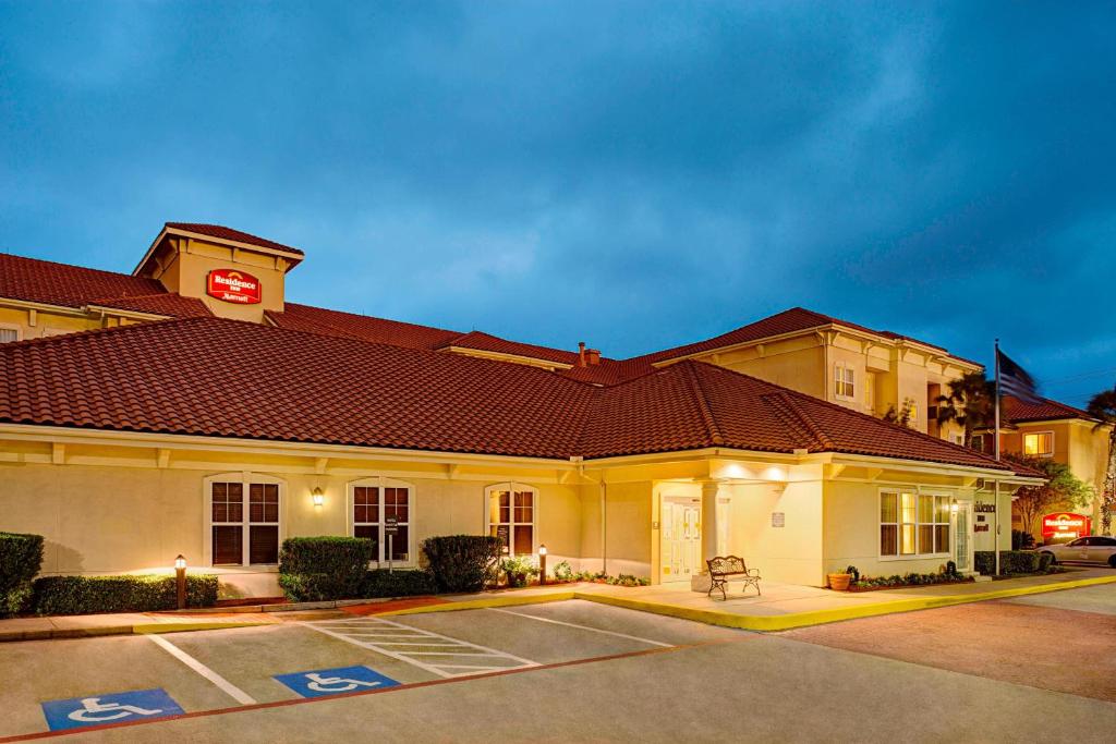 un bâtiment avec un parking en face de celui-ci dans l'établissement Residence Inn Houston - West University, à Houston