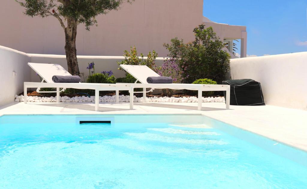 a swimming pool with two lounge chairs and a table at Amy Villa , Agios Prokopis in Agios Prokopios