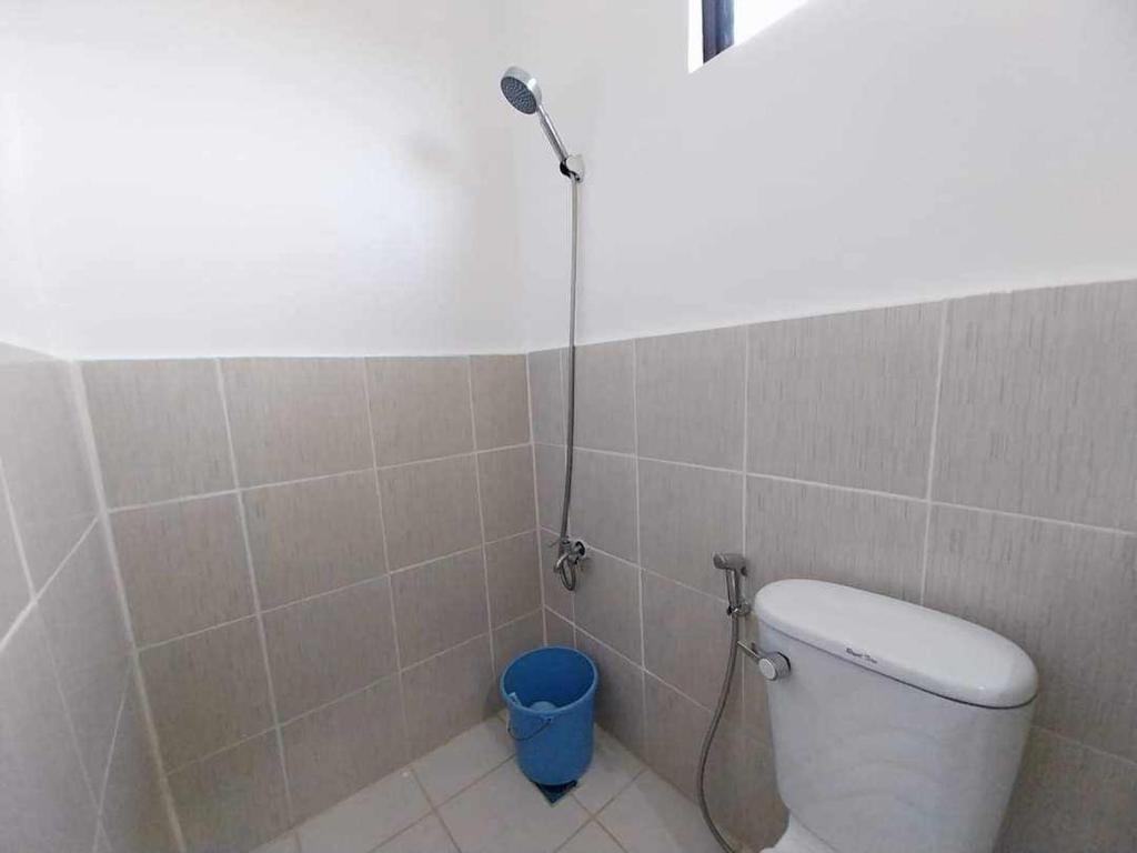 a shower in a bathroom with a toilet and a bucket at Bungalow House-Olango Island in Lapu Lapu City