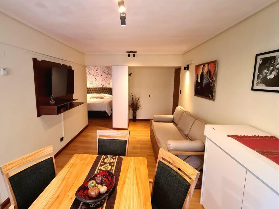 een woonkamer met een bank en een tafel bij Apartamento Urquiza in Bariloche