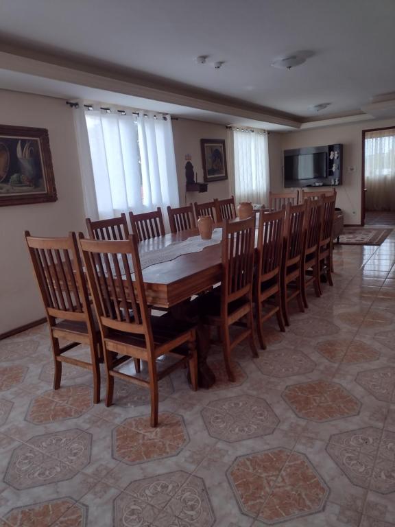 uma sala de jantar com uma mesa de madeira e cadeiras em Aconchego Mineiro em São João del Rei