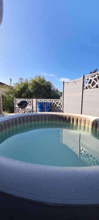 una piscina d'acqua con un ponte sullo sfondo di Agréable Villa à mi-chemin de Paris & Disneyland & Stade de France a Gagny