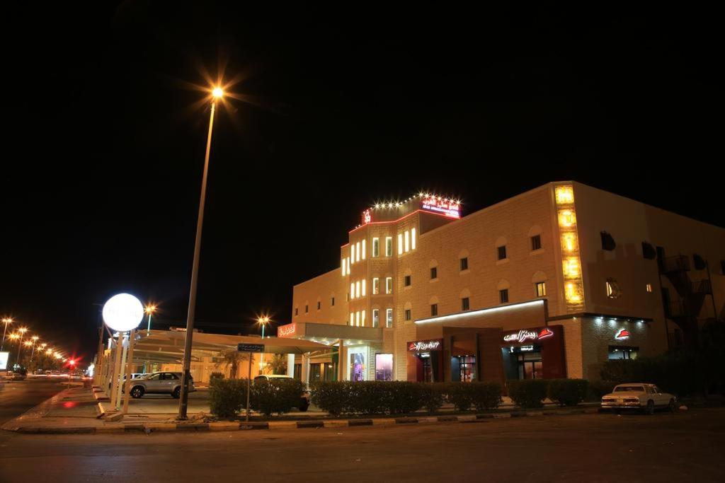a building with a street light in front of it at night at فندق سفير العرب in Rafha