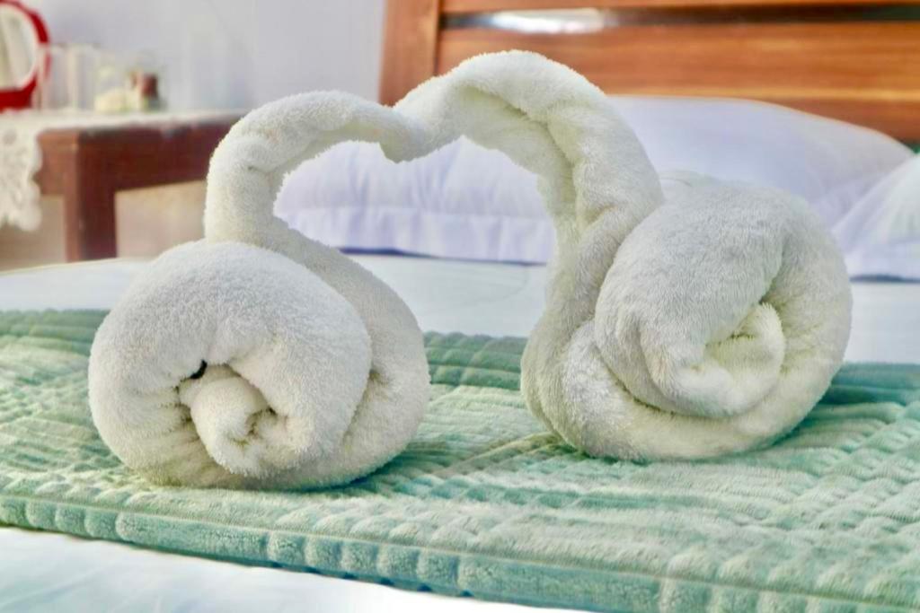 two swans are making a heart shape on a bed at Tangkoko Homestay in Rinondoran