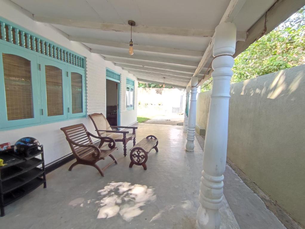 a porch with two rocking chairs and a table at Home sweet in Ahanagama villa in Ahangama
