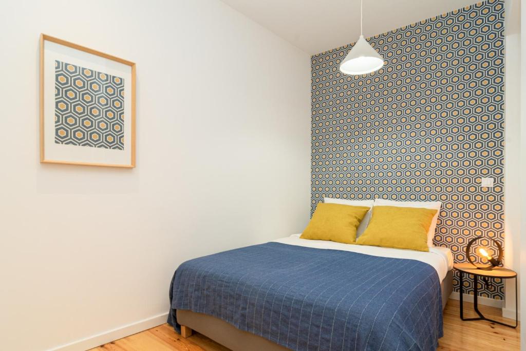 - une chambre avec un lit et un mur bleu et blanc dans l'établissement Arroios Concept Apartments by Homing, à Lisbonne