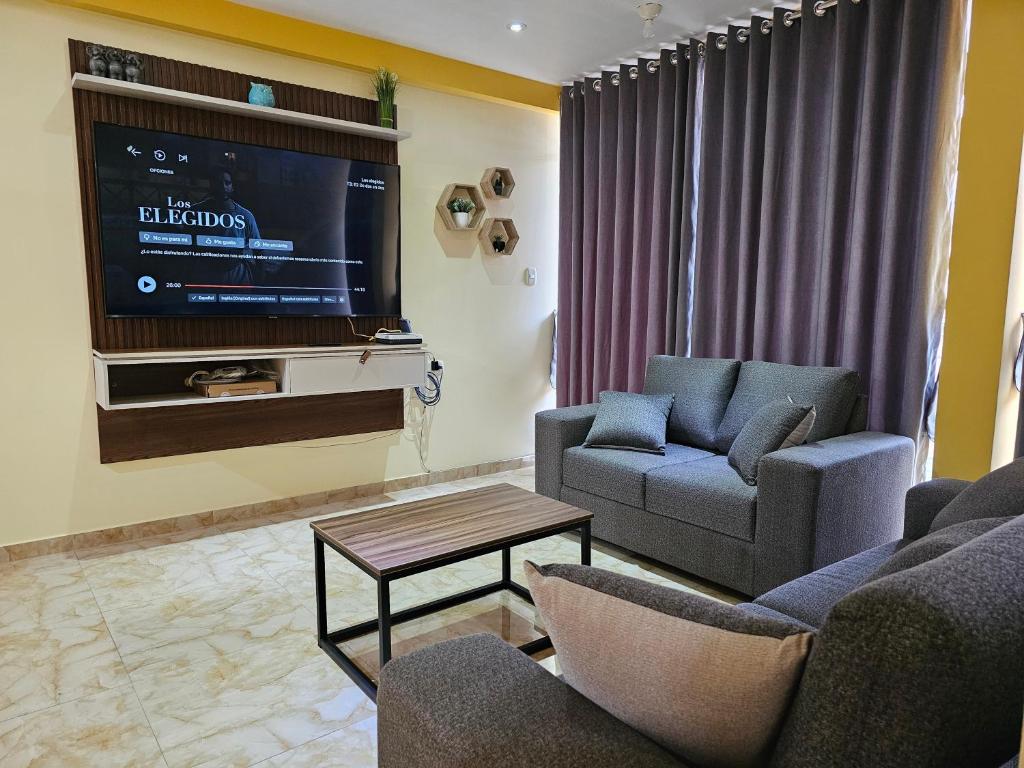 sala de estar con 2 sillas y TV en Departamento en Huanchaco Beach, en Huanchaco