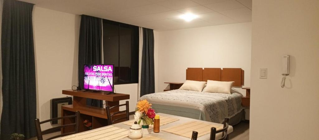 Monoambiente acogedor, cómodo e iluminado في لاباز: غرفة بسرير وطاولة مع تلفزيون