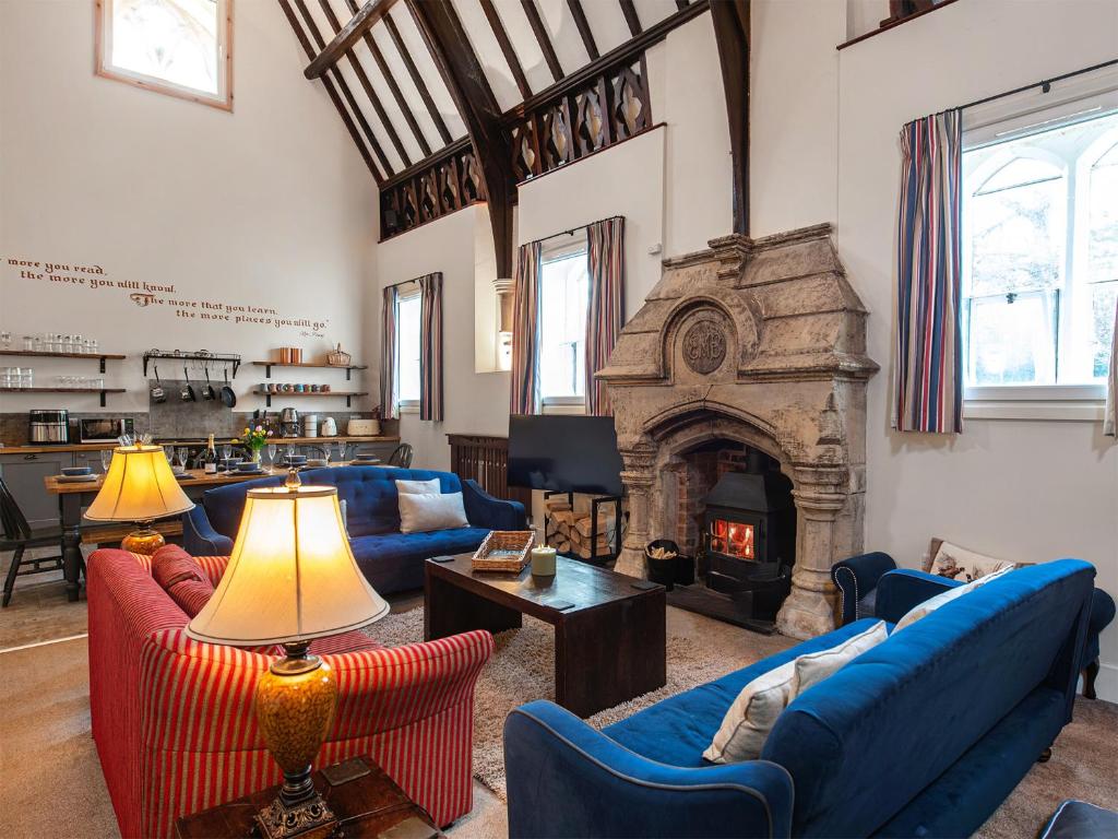 a living room with blue couches and a fireplace at The Old School House 1-uk32061 in Burwarton