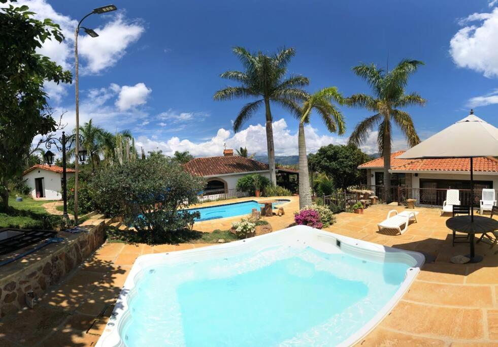 a large swimming pool in a yard with a house at Finca Hacienda Casa Prada in Bucaramanga