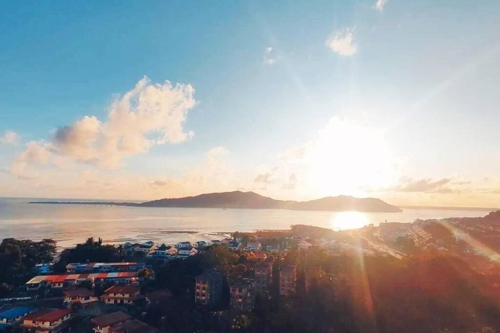 een uitzicht op de zonsondergang boven het water bij Sea view apartment level 21, sunrise view in Sandakan