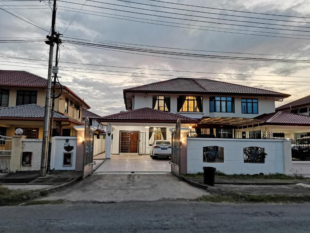 a house with a car parked in front of it at Jiuhao Homestay 九号民宿 15pax Stay Near Airport & City by Greenage in Kampong Nasob