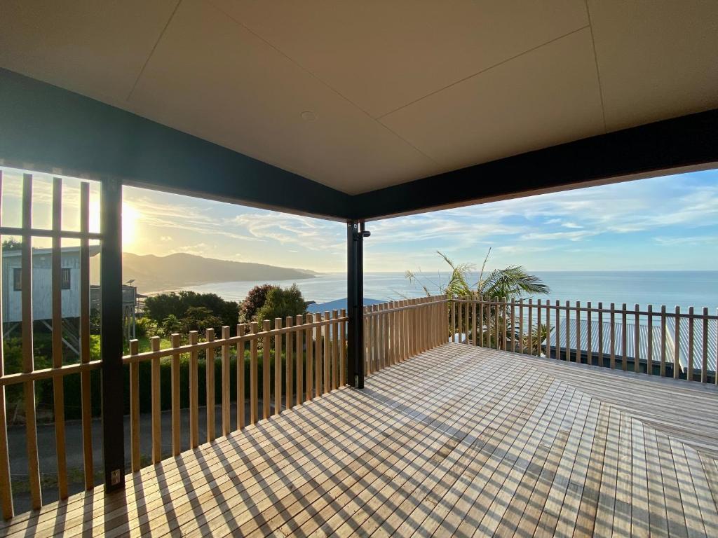 a balcony with a view of the ocean at Ahipara Beach Pad in Ahipara