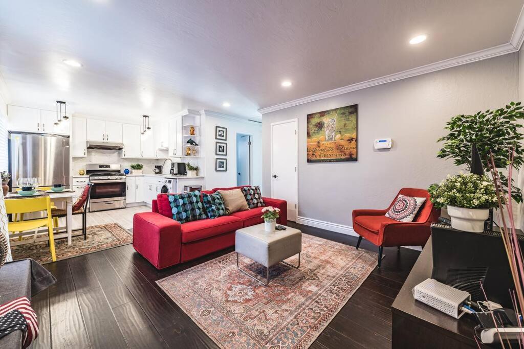 ein Wohnzimmer mit einem roten Sofa und einer Küche in der Unterkunft Stanford Traveler's love & Cozy Bay trail house in East Palo Alto