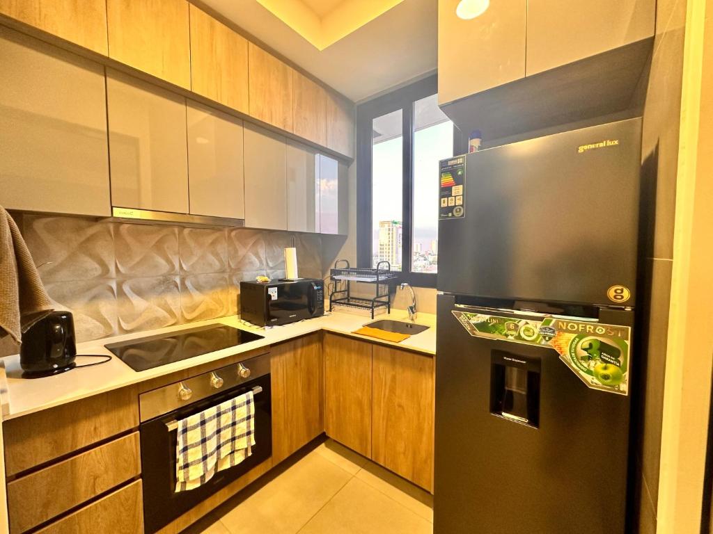 uma cozinha com um frigorífico preto e um lavatório em Departamento de lujo en zona exclusiva em Santa Cruz de la Sierra
