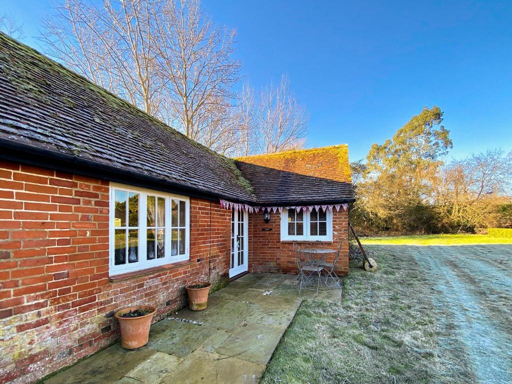 a brick house with a patio in front of it at Oaklands Farm - Cottage 4 in Broughton
