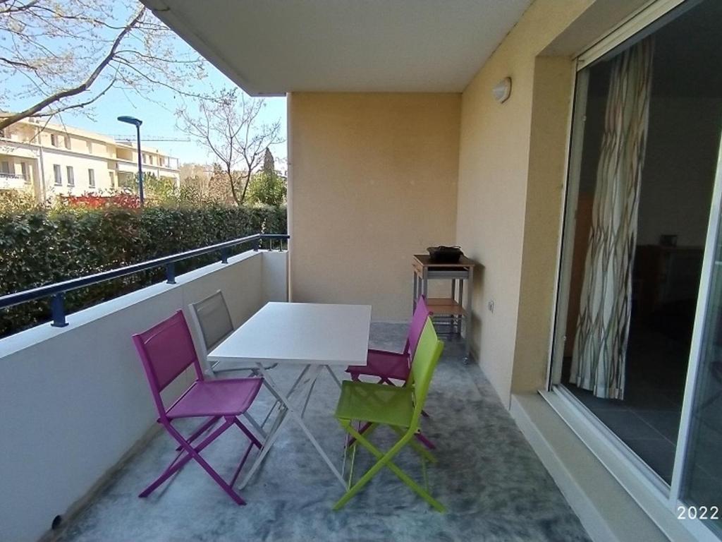 d'une table et de quatre chaises sur un balcon. dans l'établissement Appartement 4 pers, piscine, terrasse avec BBQ, parking, proche plage – Argelès-sur-Mer - FR-1-776-27, à Argelès-sur-Mer