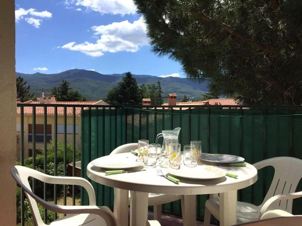 une table blanche avec des assiettes et des verres sur un balcon dans l'établissement Appartement 2 Pièces pour 4 personnes - Proche Plage, Port et Commerces - FR-1-776-30, à Argelès-sur-Mer