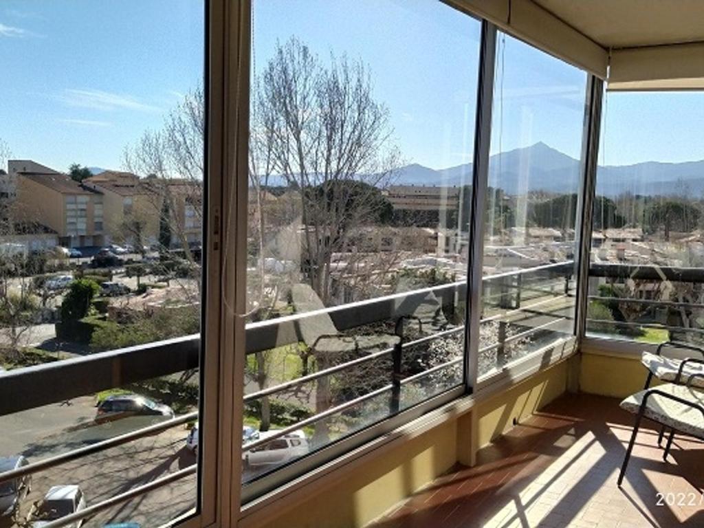 Elle comprend un balcon doté de fenêtres offrant une vue sur la ville. dans l'établissement Appartement climatisé 2 pièces avec parking, animaux admis, 500m de la plage - FR-1-776-38, à Argelès-sur-Mer