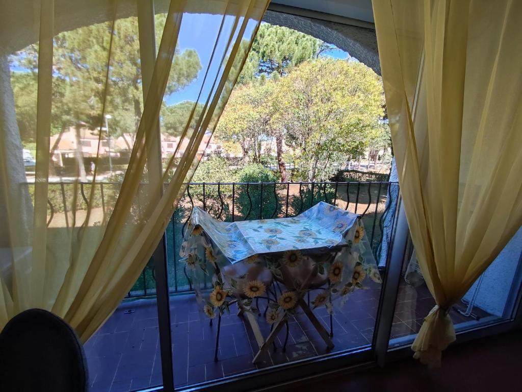 - une fenêtre avec un parasol sur le balcon dans l'établissement Appartement Climatisé 4 Pers, Piscine, Tennis, Proche Plage - FR-1-776-45, à Argelès-sur-Mer