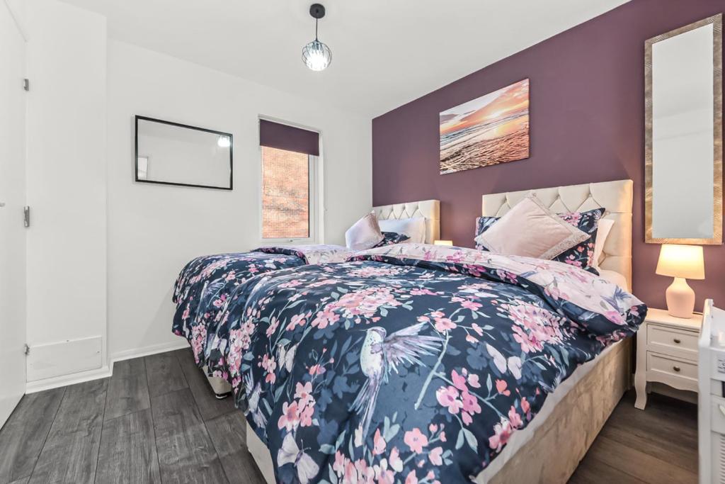 a bedroom with a bed with a floral bedspread at Sutton Apartment, Greater London in Sutton