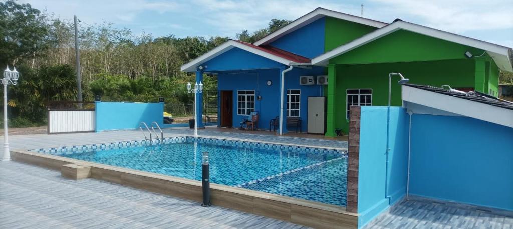 een huis met een zwembad ervoor bij Maksu homestay in Kuala Nerang