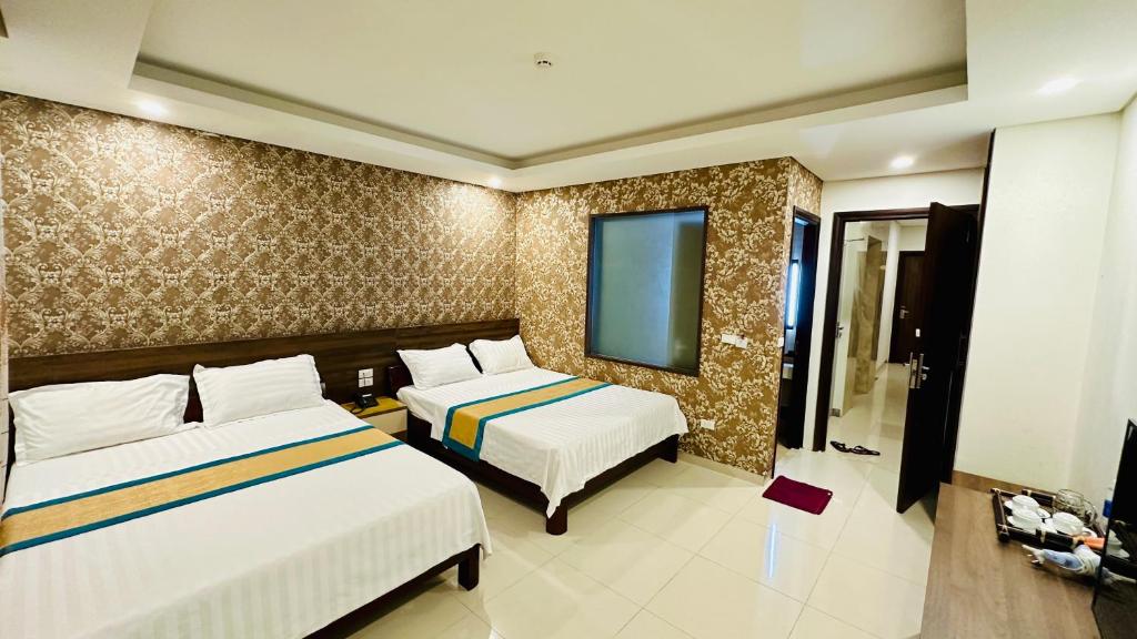 Cette chambre comprend deux lits et une télévision. dans l'établissement May Hotel Sonasea Phu Quoc, à Duong Dong