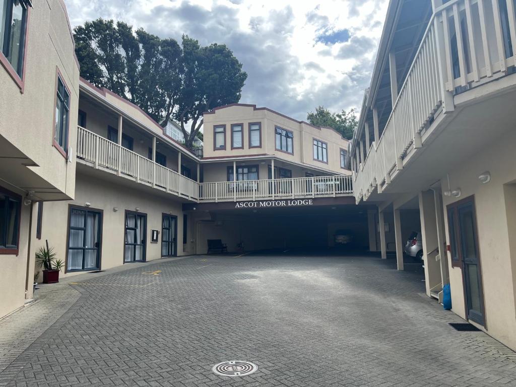 an empty parking lot in a courtyard of a building at Ascot Motor Lodge in Wellington