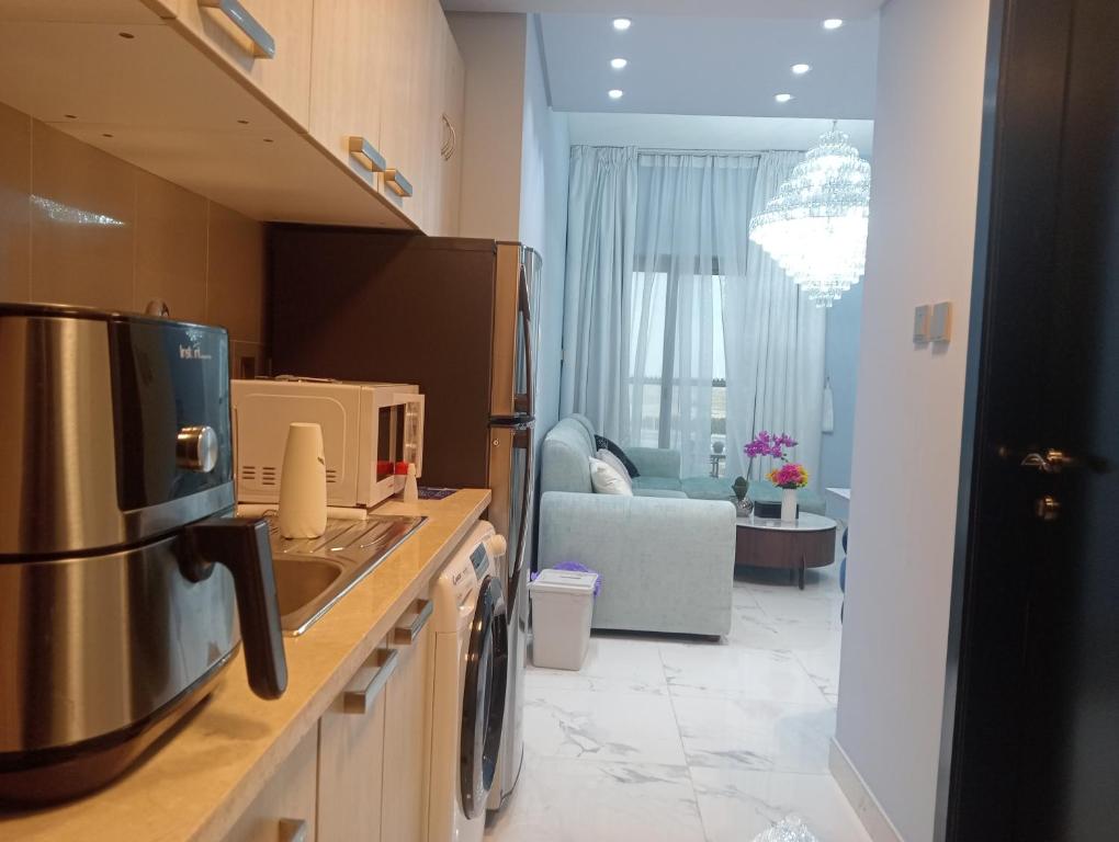 een keuken met een wastafel en een woonkamer bij Mag5 in Dubai