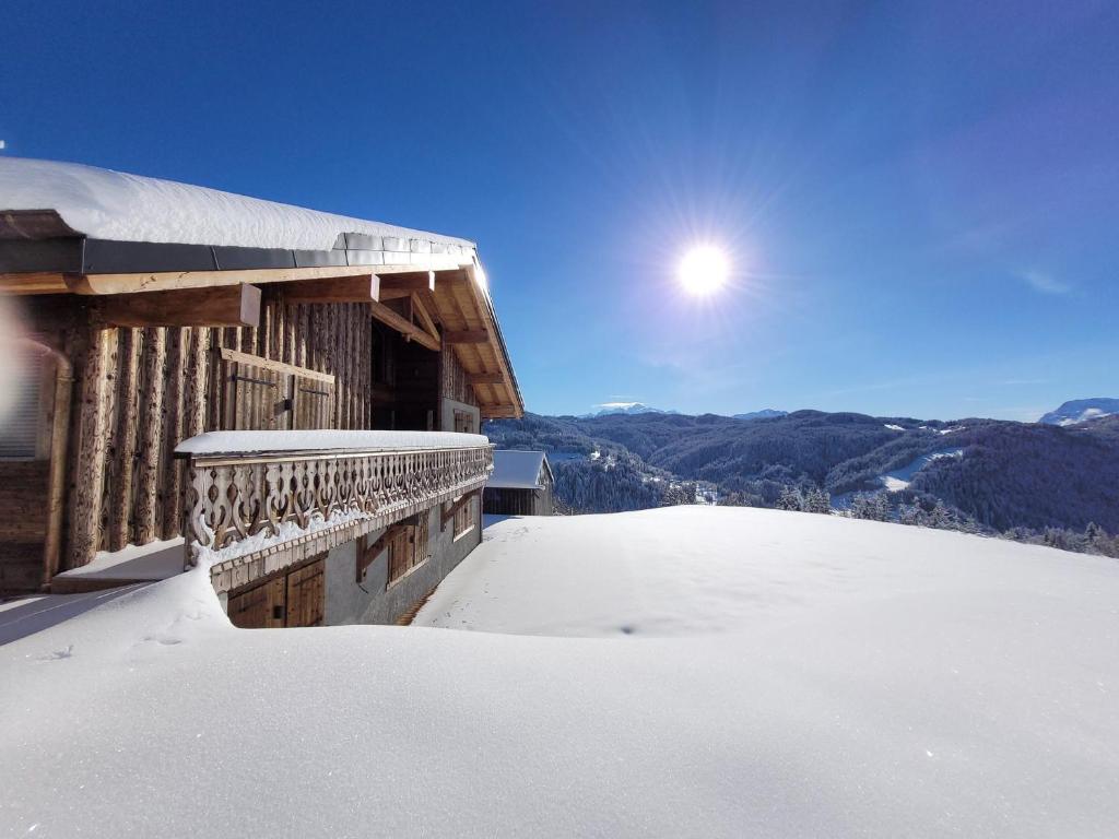 a snow covered roof of a building with the sun in the sky at Chalet Les Gets, 8 pièces, 14 personnes - FR-1-598-161 in Les Gets