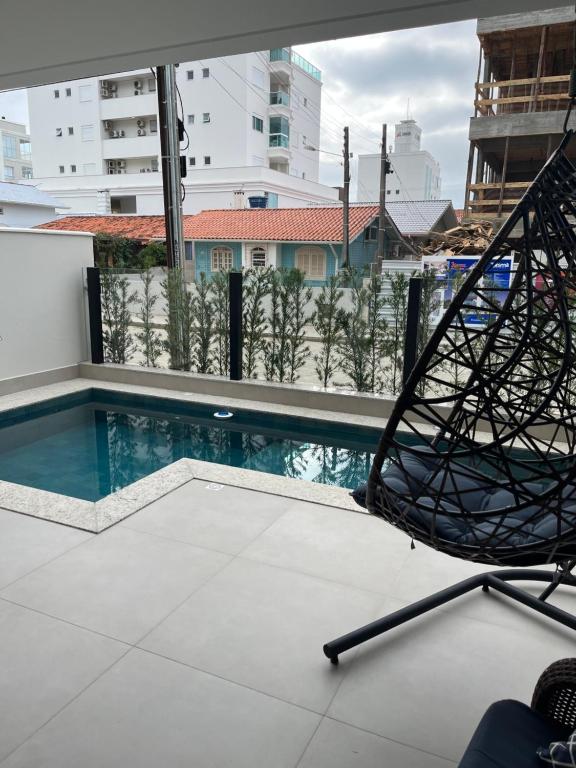 - une vue sur la piscine depuis un bâtiment dans l'établissement Apartamento com piscina a 100 metros da praia, à Governador Celso Ramos
