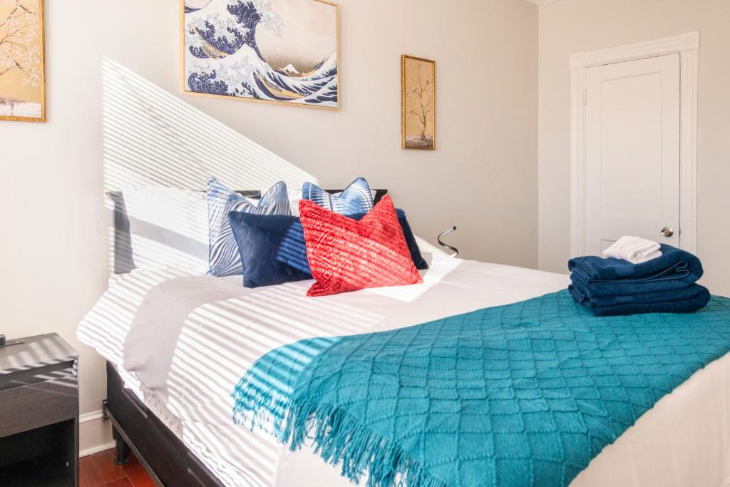 Una cama blanca con almohadas azules y rojas. en Charming 4 Bedroom House!1 Mile from Capitol Hill! en Washington