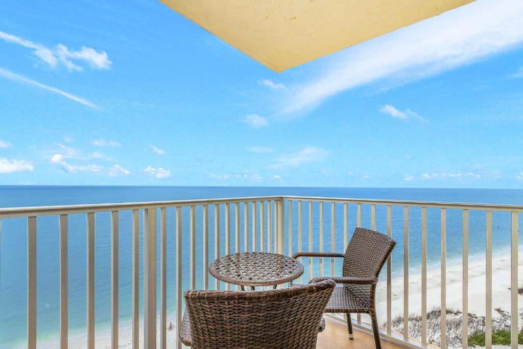 una mesa y 2 sillas en un balcón con vistas al océano en Estero Beach and Tennis PH5 Building C condo, en Fort Myers Beach