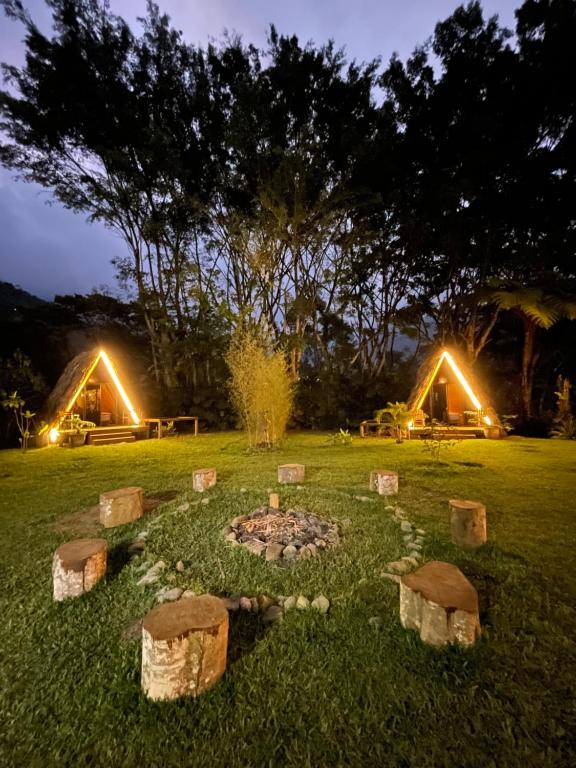 einen Garten mit einer Feuerstelle im Gras in der Nacht in der Unterkunft ALMAH GLAMPING in Cali