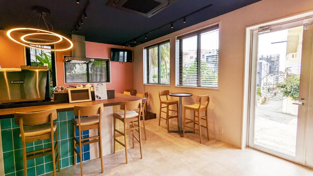 a kitchen with a bar with stools and a window at MAHHO TERRACE MIYAKO in Miyako-jima