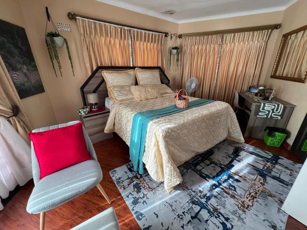a bedroom with a bed and a chair at The Silver Gates Bed and Breakfast in Mbabane