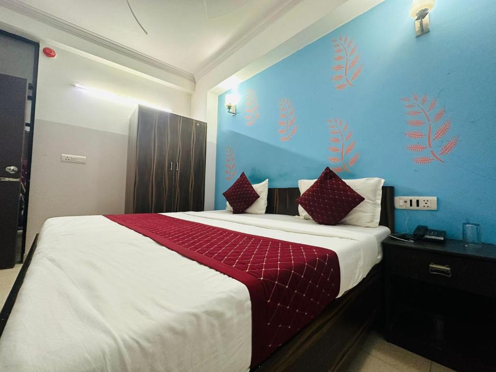 a bedroom with a large bed with a red blanket at Hotel Galaxy Inn Near Delhi International Airport in New Delhi